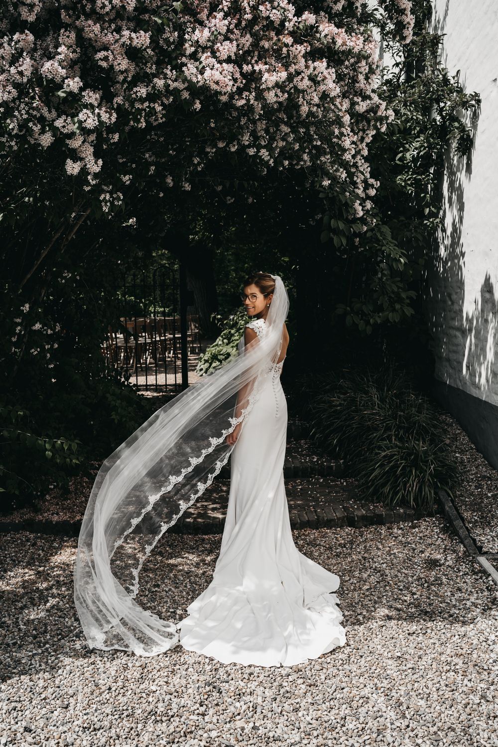 carola in bruidsjurk onder boom